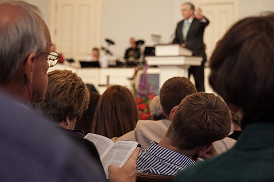 Church congregation listening to ordained minister's sermon